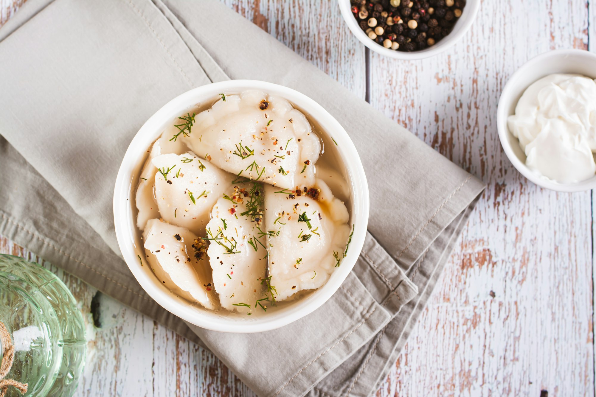 Traditional dumplings soup with herbs and spices in a bowl on the table top view