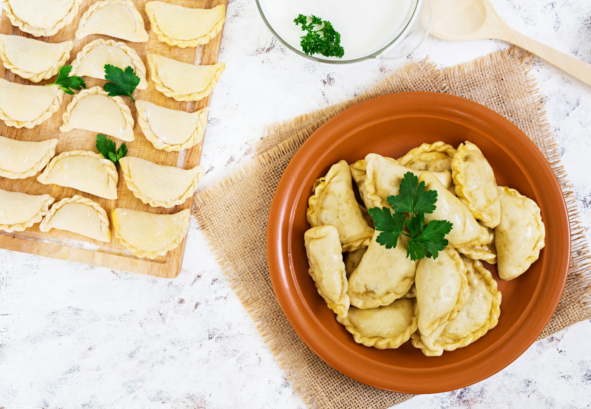 Delicious dumplings with cabbage on white background. Top view